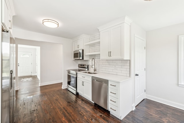 kitchen with appliances with stainless steel finishes, white cabinetry, sink, and dark hardwood / wood-style floors