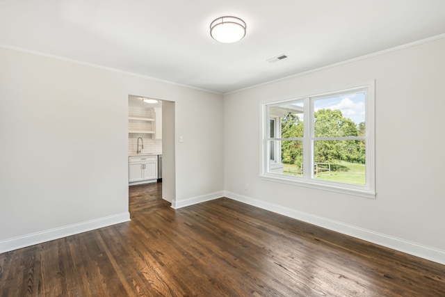 spare room featuring sink, dark hardwood / wood-style floors, and crown molding