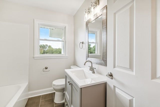 bathroom featuring a healthy amount of sunlight, vanity, toilet, and tile patterned floors