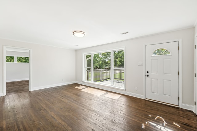 entrance foyer with ornamental molding, plenty of natural light, and dark hardwood / wood-style floors