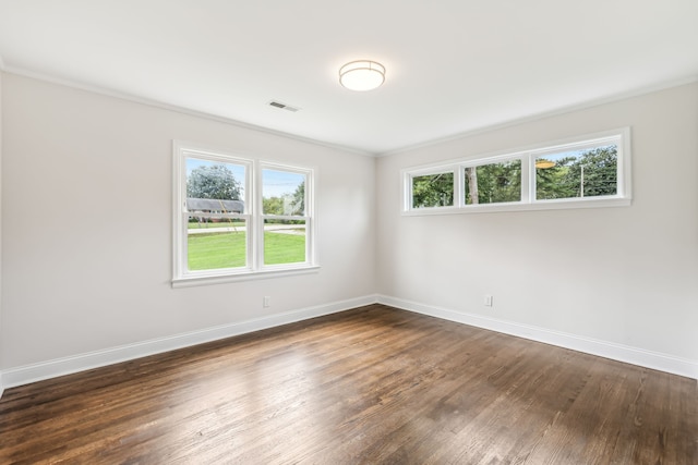 spare room featuring ornamental molding and dark hardwood / wood-style flooring