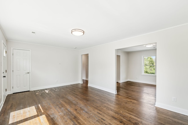 spare room with ornamental molding and dark hardwood / wood-style flooring