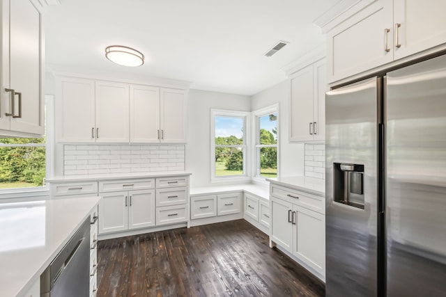 kitchen with white cabinetry, appliances with stainless steel finishes, and dark hardwood / wood-style floors