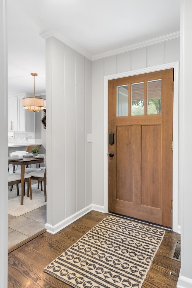 entrance foyer featuring crown molding and dark hardwood / wood-style flooring