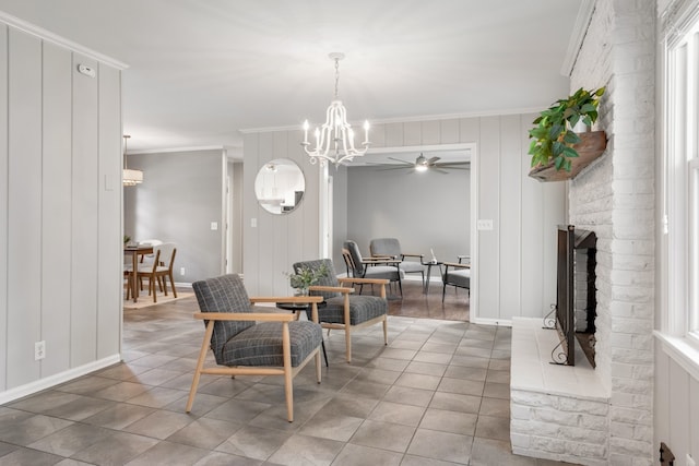 tiled dining area featuring ceiling fan with notable chandelier, ornamental molding, and a brick fireplace