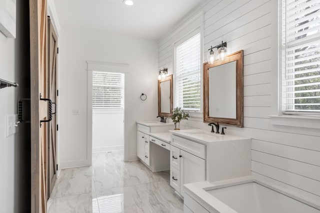 bathroom featuring vanity, a tub, and plenty of natural light