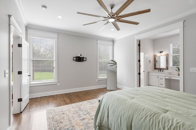 bedroom featuring wood-type flooring, crown molding, ensuite bath, and ceiling fan