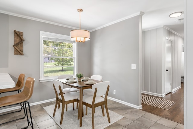 dining room with light hardwood / wood-style flooring and ornamental molding