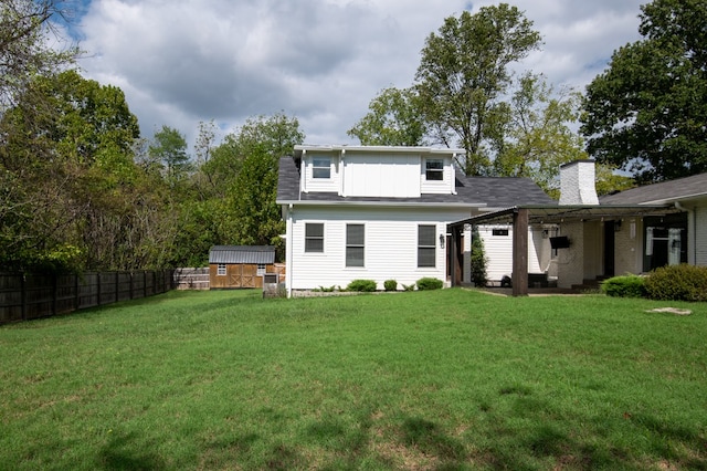 back of property with a storage unit, a patio area, and a lawn