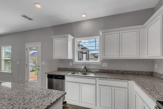 kitchen with a wealth of natural light, white cabinetry, and sink