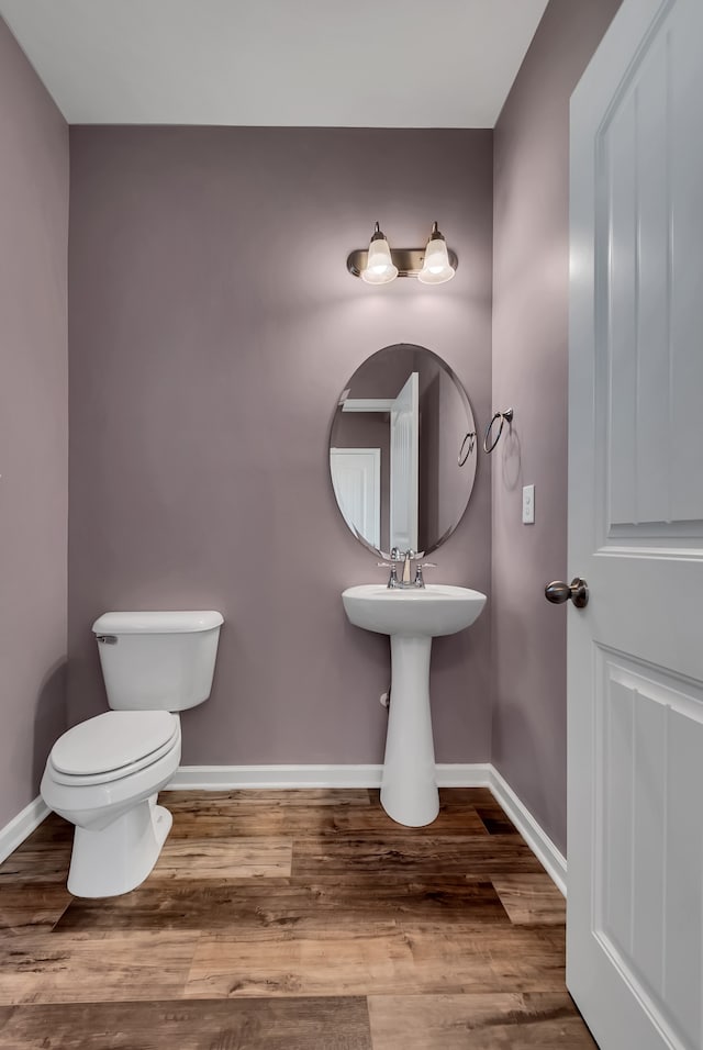 bathroom with wood-type flooring and toilet