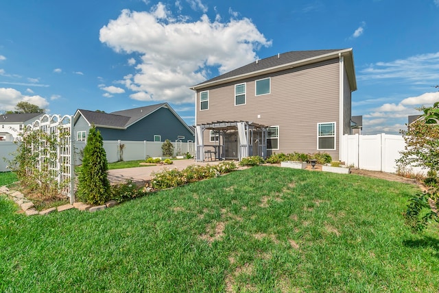 back of property with a patio, a yard, and a pergola