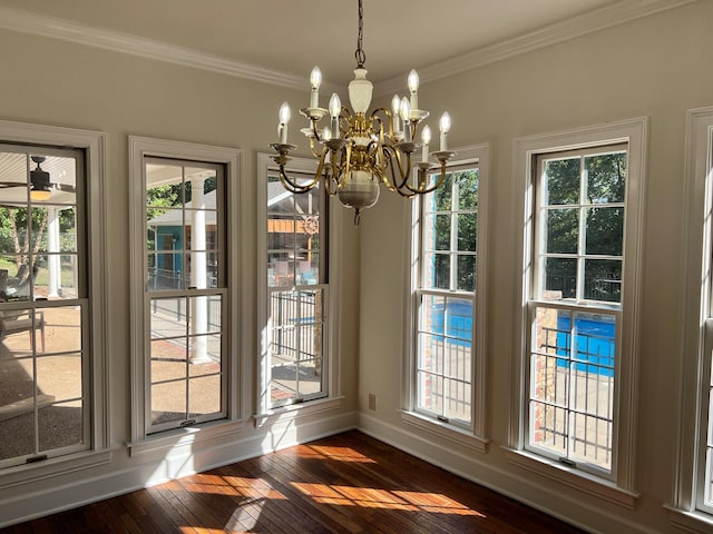 unfurnished dining area with ceiling fan with notable chandelier, crown molding, and dark wood-type flooring