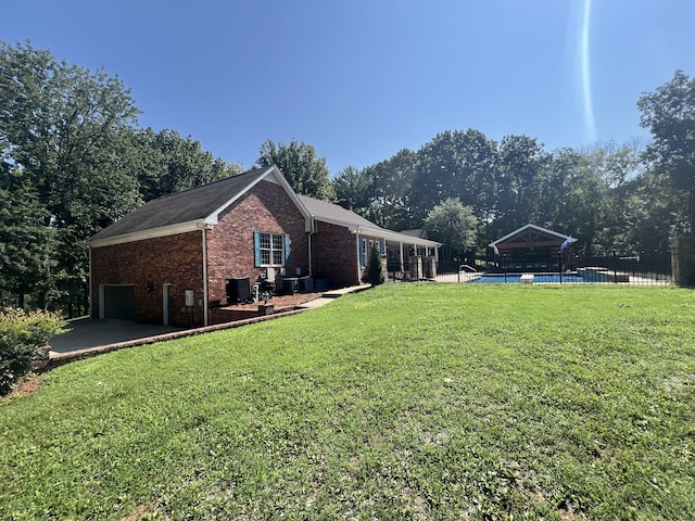 view of home's exterior featuring a lawn and a fenced in pool