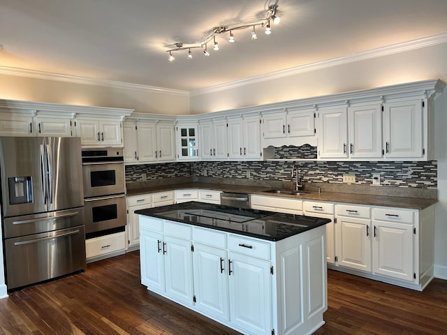 kitchen with sink, white cabinetry, stainless steel appliances, dark hardwood / wood-style flooring, and ornamental molding