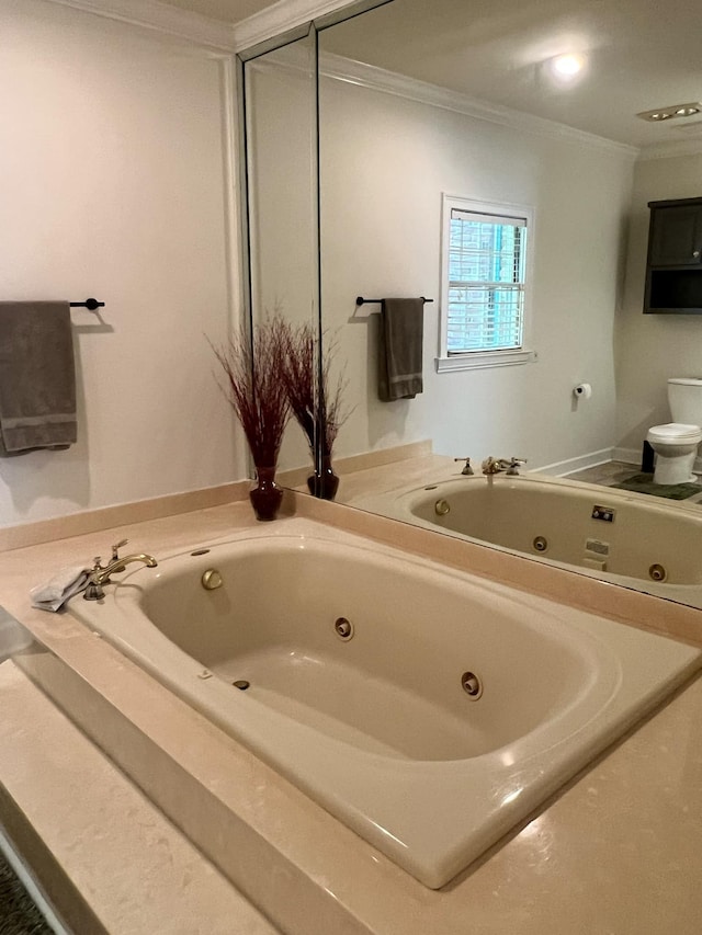 bathroom with ornamental molding, a bathing tub, and toilet