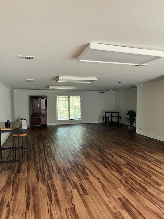 empty room featuring crown molding and dark hardwood / wood-style flooring