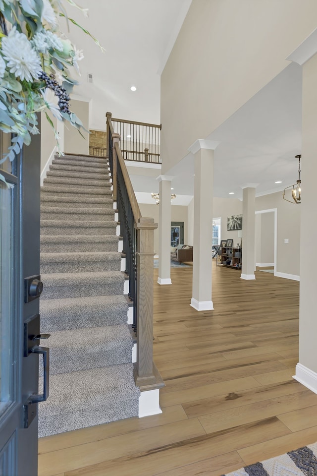 stairway with hardwood / wood-style floors and a notable chandelier