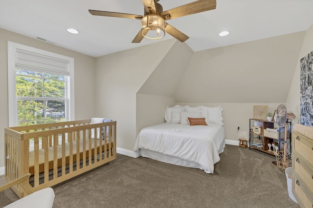 bedroom with ceiling fan, lofted ceiling, and dark colored carpet