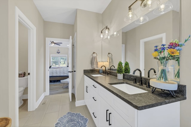 bathroom with ceiling fan, vanity, tile patterned flooring, and toilet