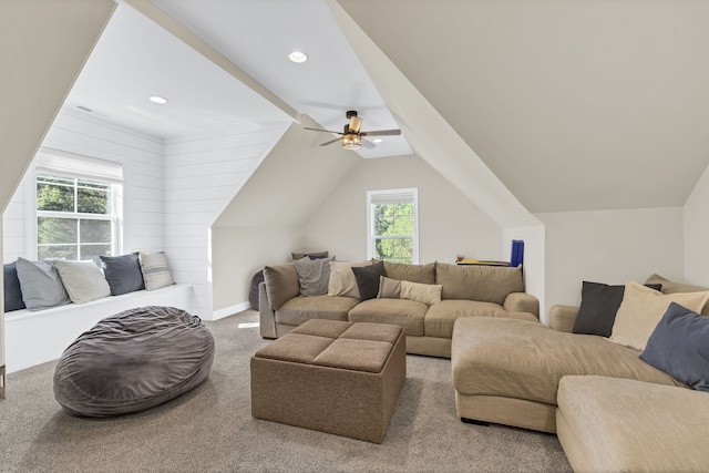 living room with lofted ceiling, wooden walls, ceiling fan, and carpet floors