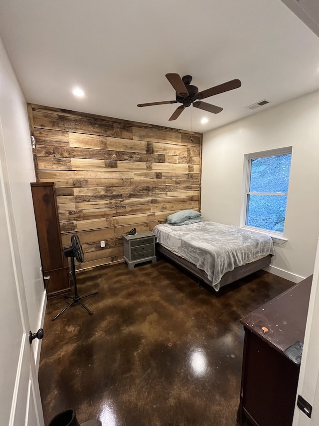 bedroom with ceiling fan and wooden walls