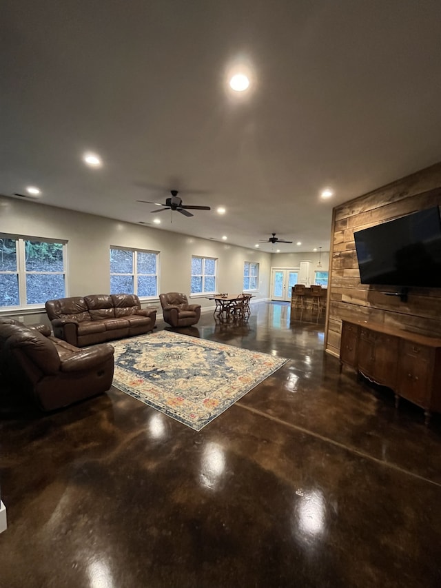 living room with ceiling fan and concrete flooring