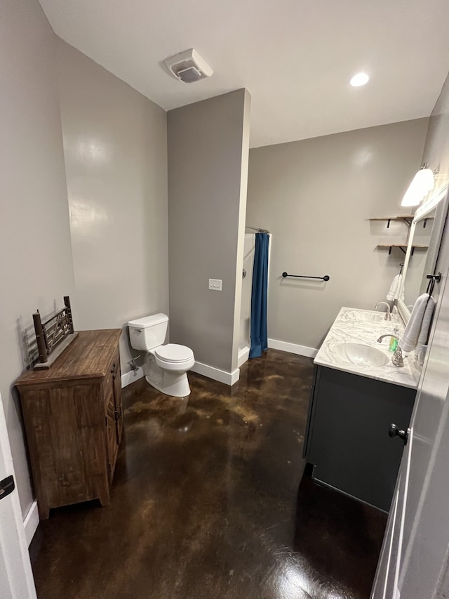 bathroom with concrete floors, vanity, and toilet