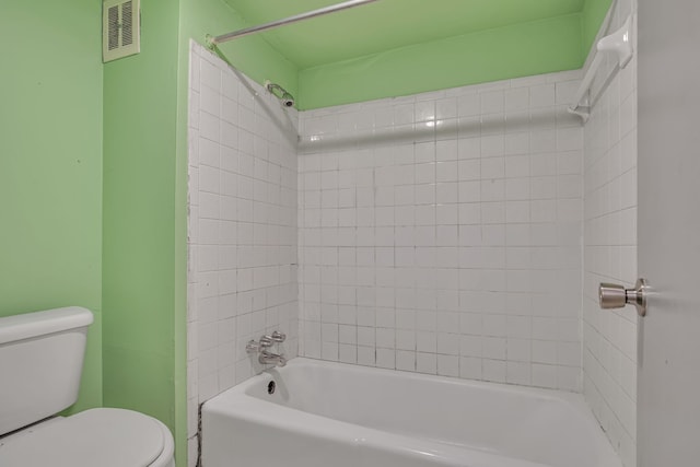 bathroom featuring tiled shower / bath and toilet