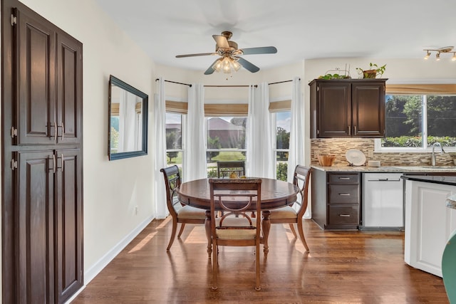 dining space with ceiling fan, dark hardwood / wood-style floors, and sink