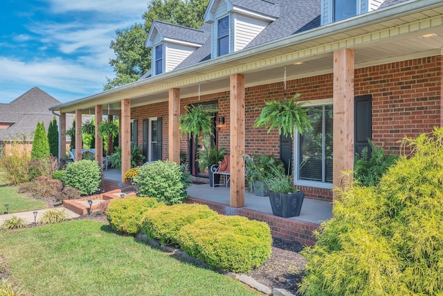 doorway to property featuring a yard and a porch