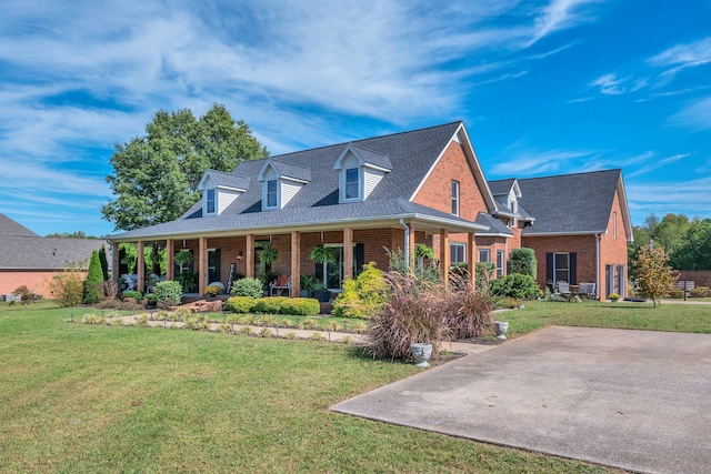 cape cod house featuring a front lawn and covered porch