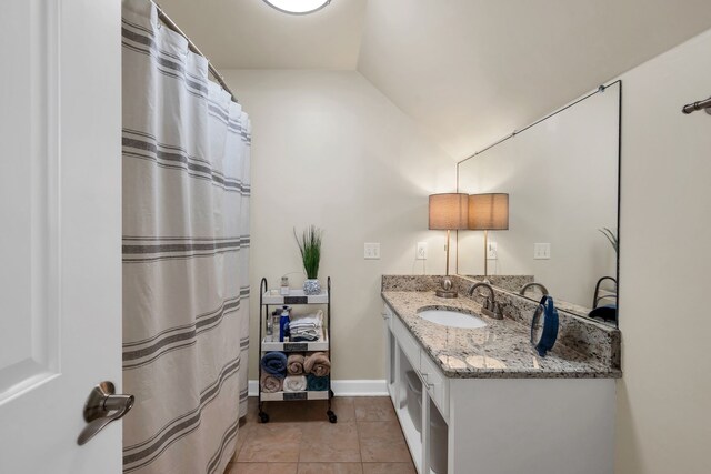 bathroom with lofted ceiling, tile patterned floors, and vanity