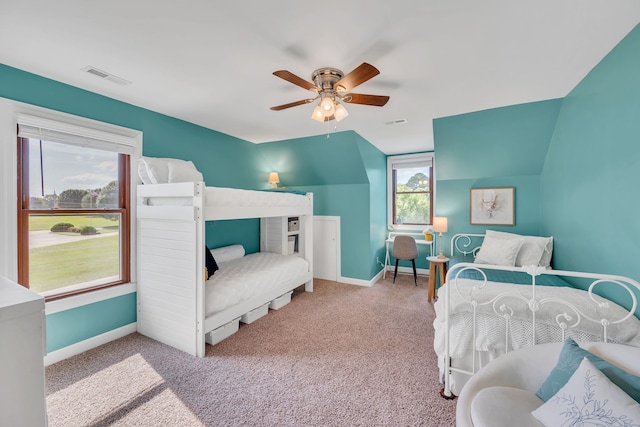 bedroom with multiple windows, vaulted ceiling, light carpet, and ceiling fan