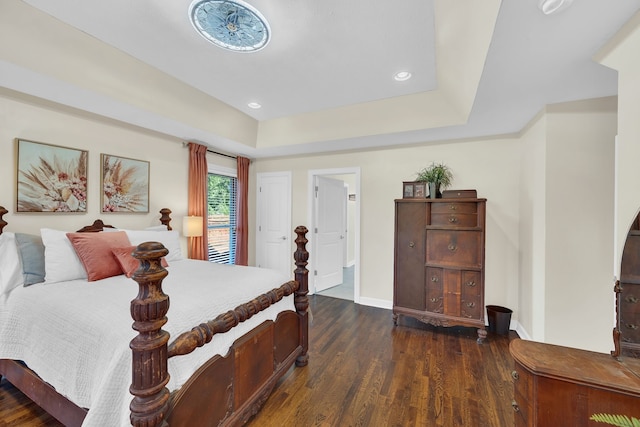 bedroom featuring a tray ceiling and dark wood-type flooring