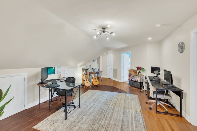 office area featuring hardwood / wood-style flooring, lofted ceiling, and a chandelier