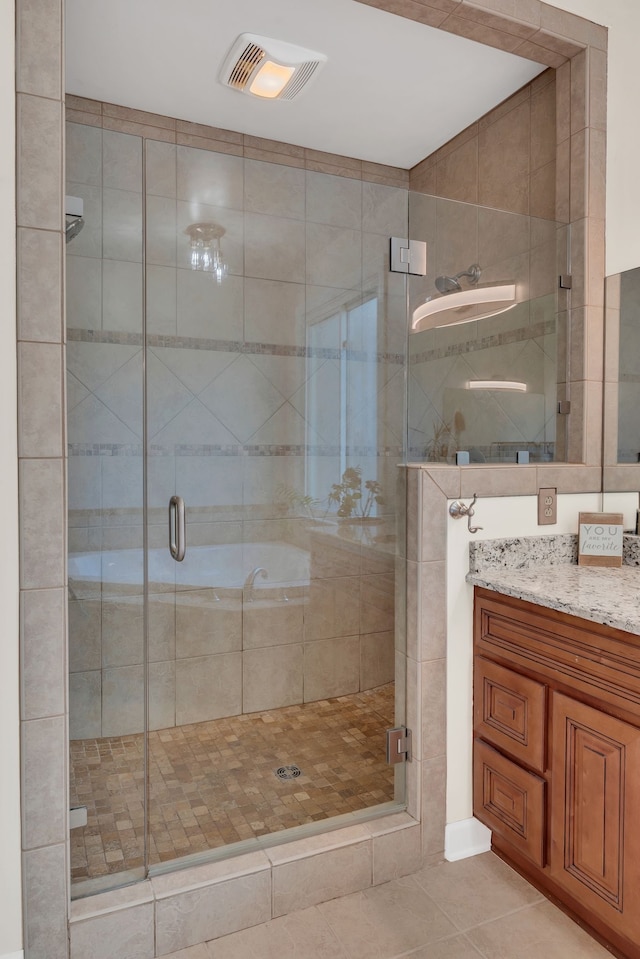 bathroom featuring vanity, a shower with shower door, and tile patterned floors