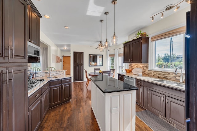 kitchen featuring dark hardwood / wood-style floors, dark brown cabinets, sink, and hanging light fixtures