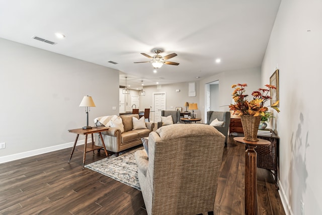 living room featuring ceiling fan and dark wood-type flooring