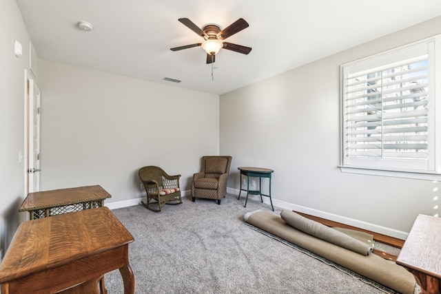 sitting room with ceiling fan and carpet flooring