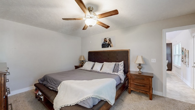 bedroom featuring a textured ceiling, light carpet, and ceiling fan