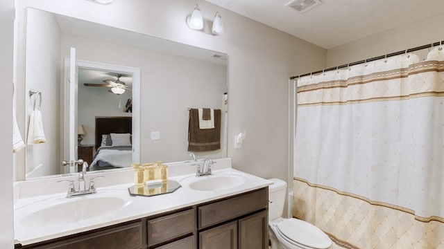 bathroom featuring a shower with shower curtain, vanity, toilet, and ceiling fan