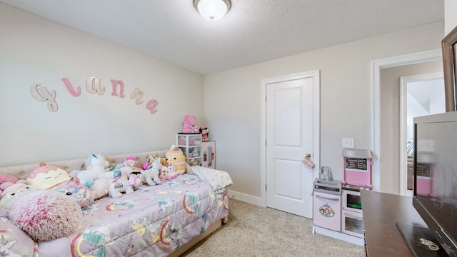 bedroom with light colored carpet and a textured ceiling