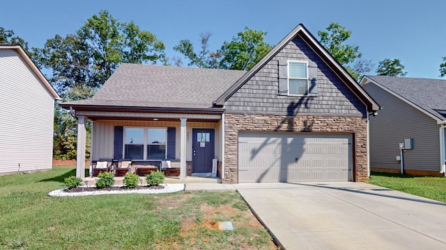 view of front of property featuring a front yard, a garage, and covered porch