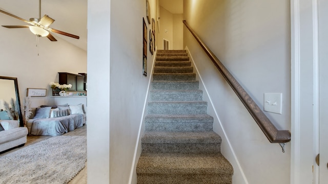 stairway with lofted ceiling and ceiling fan