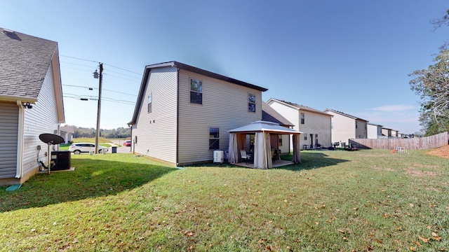 rear view of property with a gazebo and a lawn