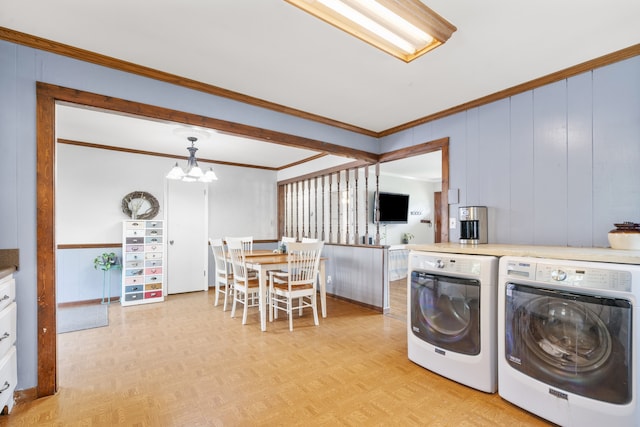 laundry room featuring an inviting chandelier, light parquet flooring, separate washer and dryer, and crown molding