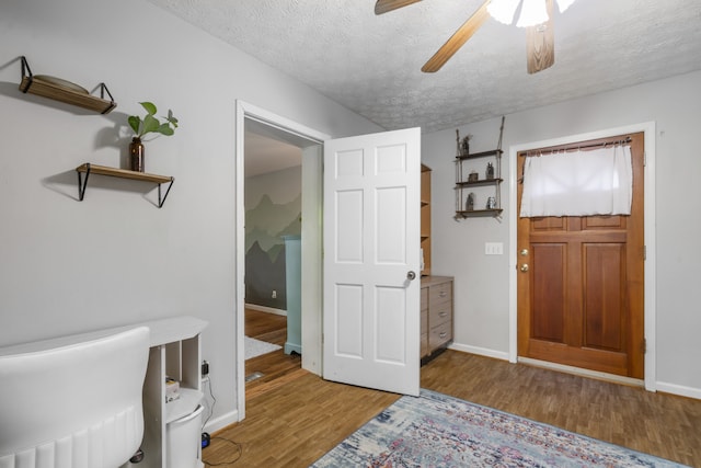 foyer featuring light hardwood / wood-style floors, ceiling fan, and a textured ceiling