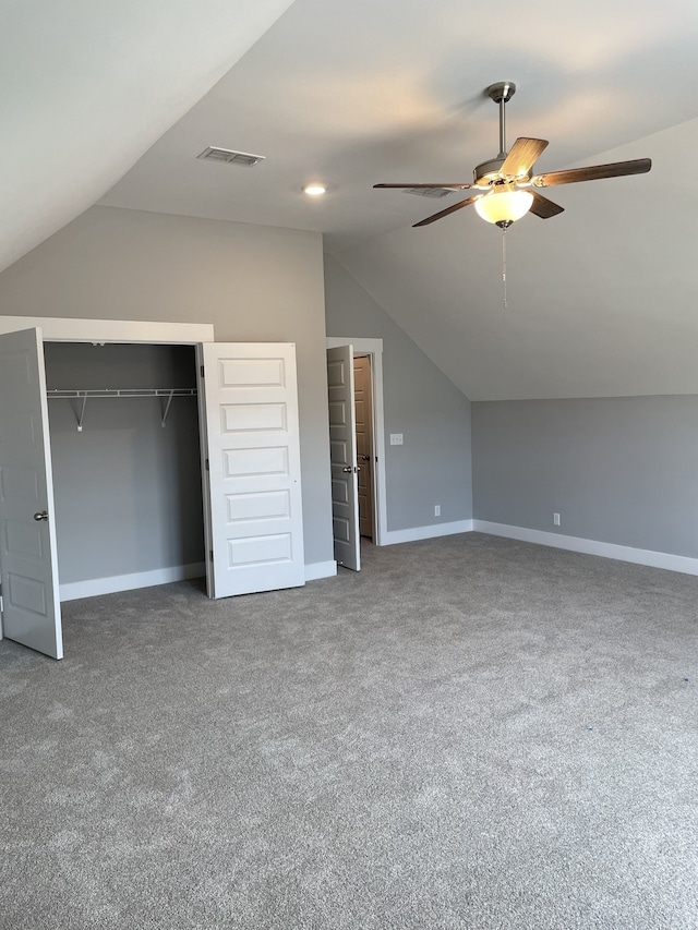 unfurnished bedroom with carpet floors, a closet, vaulted ceiling, and ceiling fan