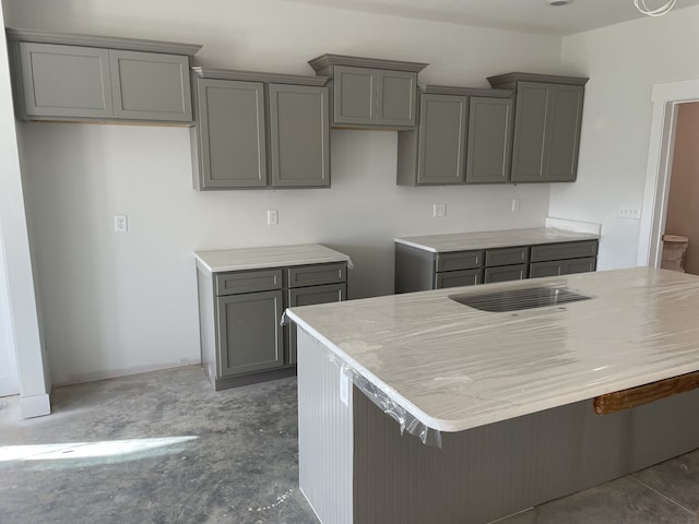 kitchen featuring a center island, gray cabinets, and a breakfast bar area